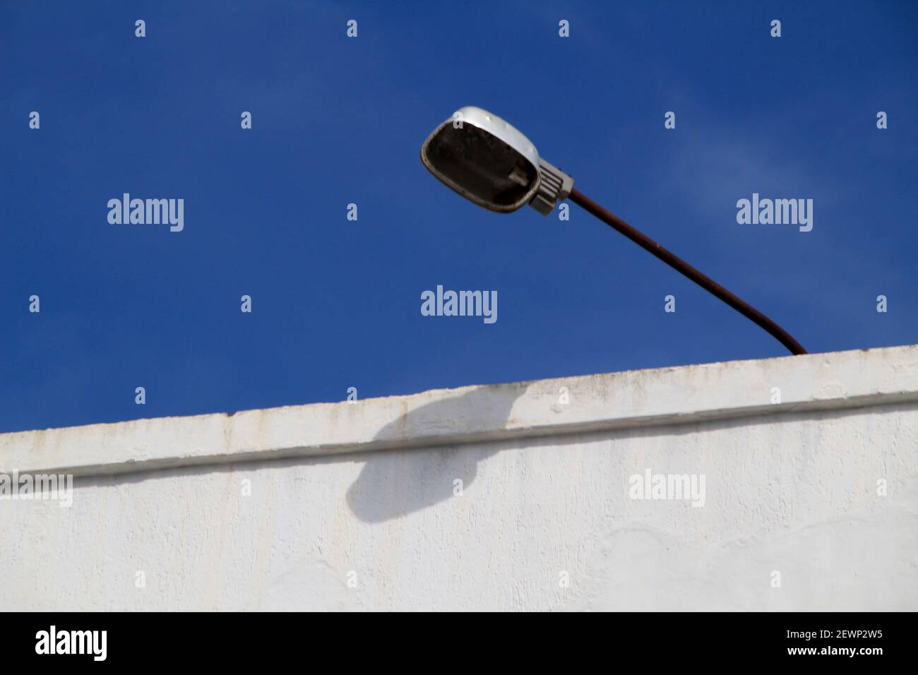 Vintage street lamp on white facade and blue sky Stock Photo