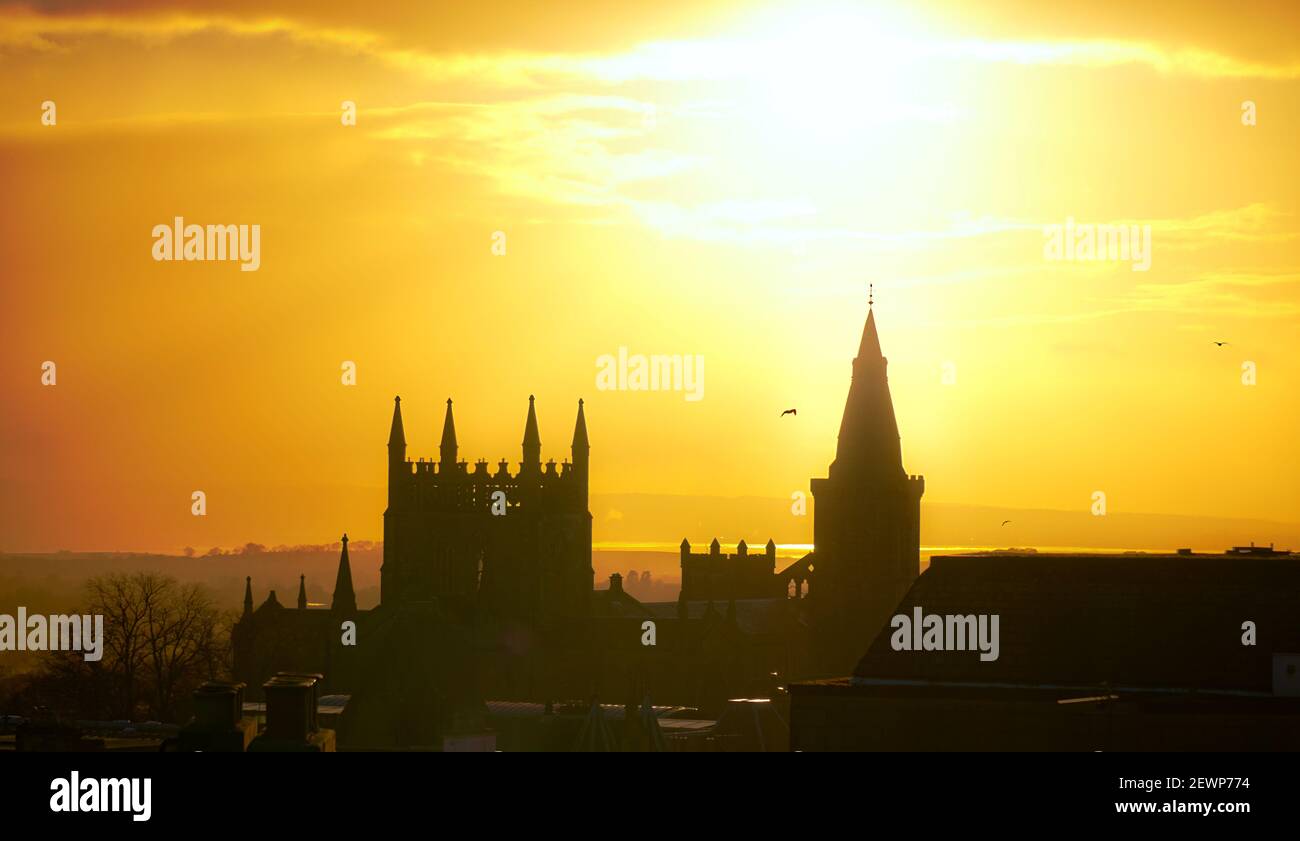 Evening sunset in hazy yellow behind Dunfermline Abbey, looking SouthWest Stock Photo