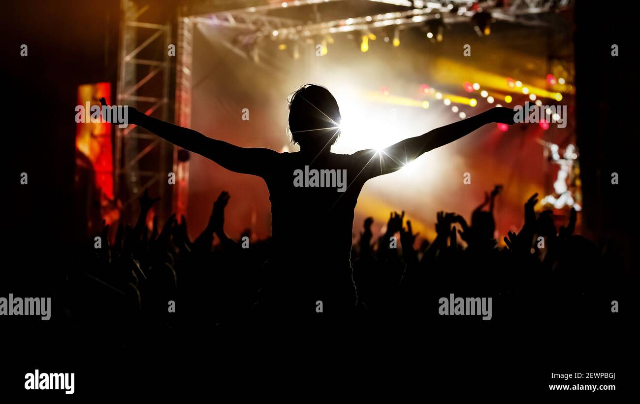 People at a public event. Black silhouettes with raised hands Stock Photo