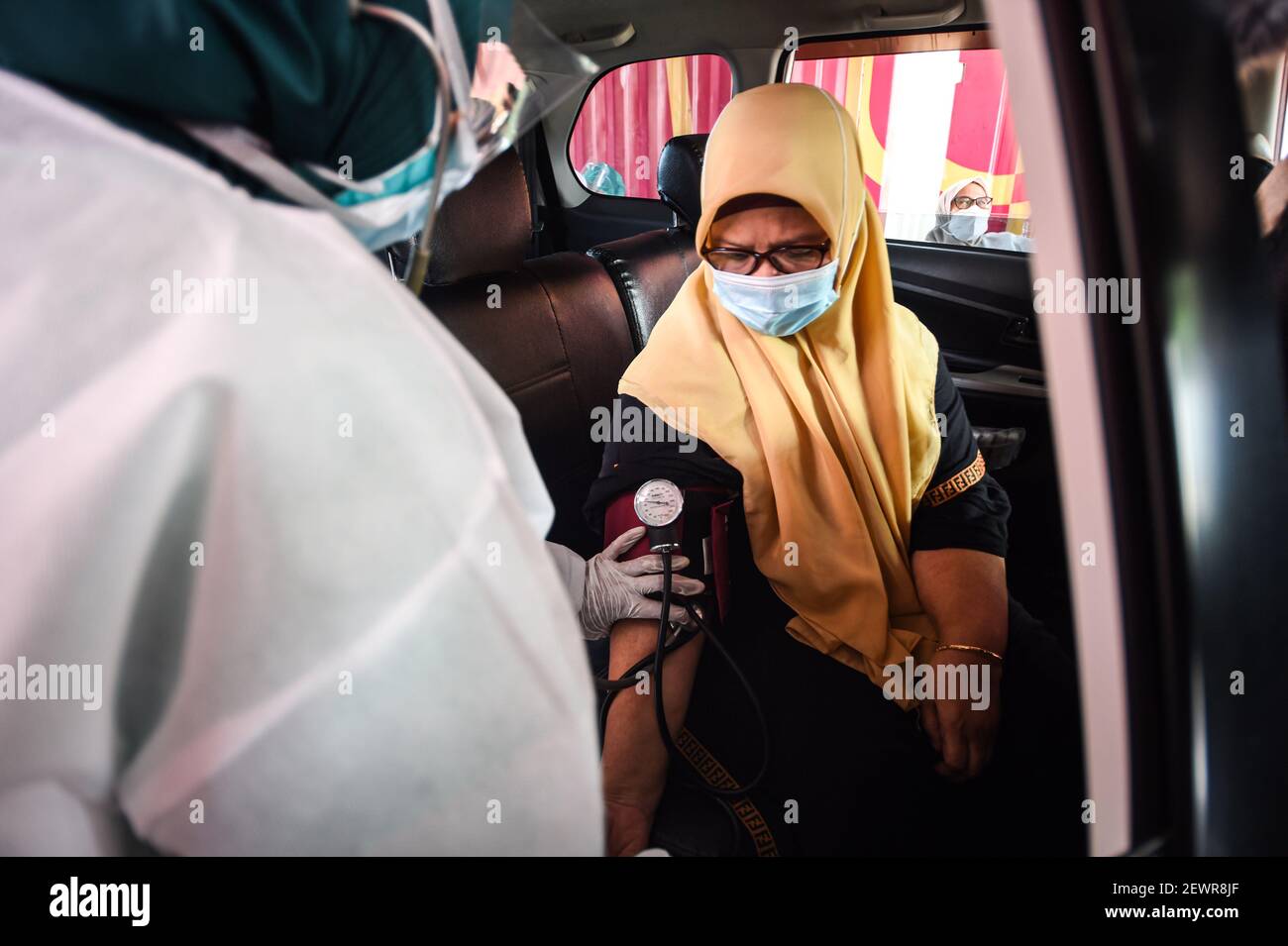 Jakarta, Indonesia. 3rd Mar, 2021. A woman has her body condition checked before receiving the COVID-19 vaccine during a drive-thru vaccination campaign for elderly people in Jakarta, Indonesia, March 3, 2021. Credit: Agung Kuncahya B./Xinhua/Alamy Live News Stock Photo