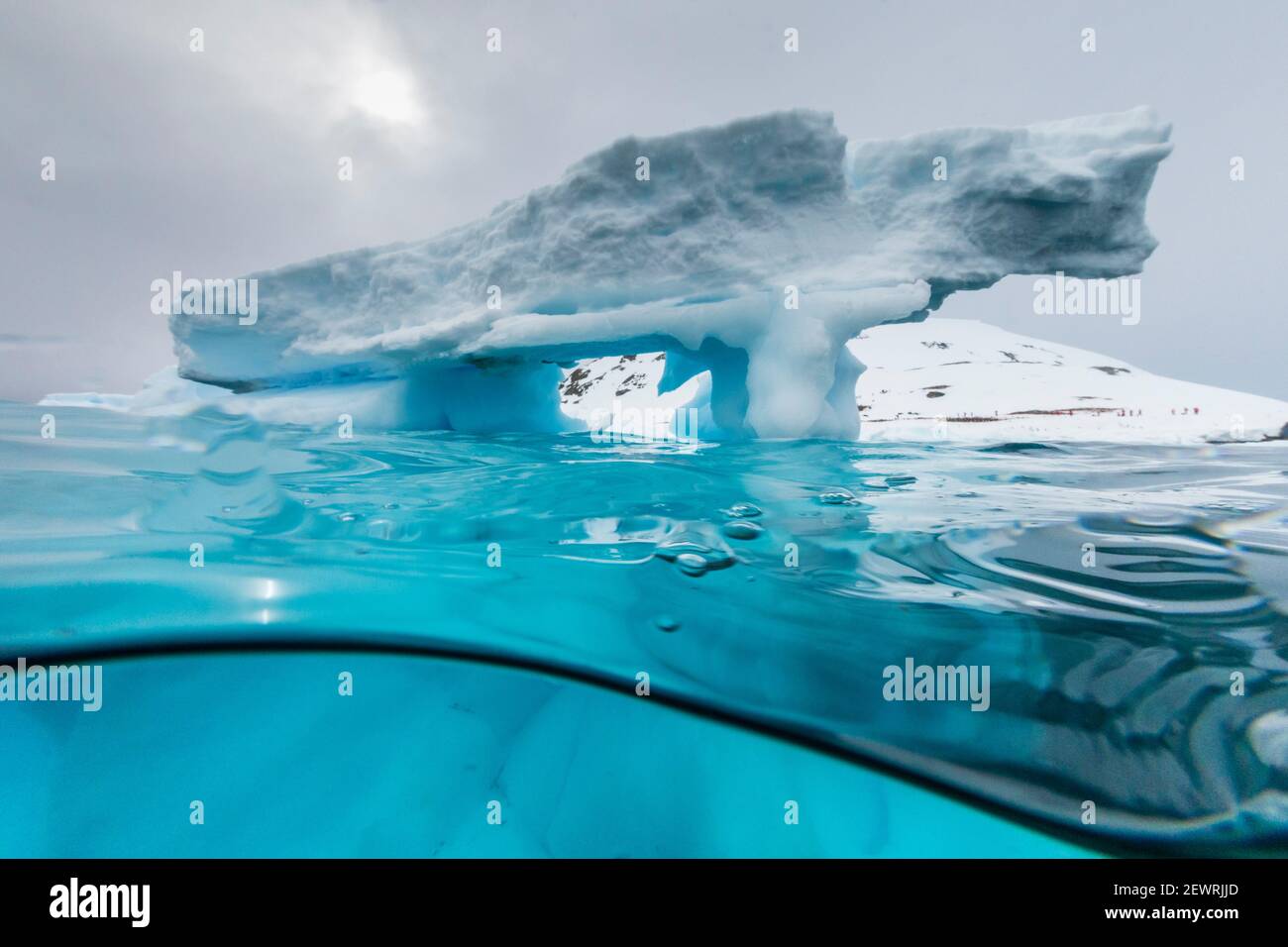 Above and below view of an arch formed in an iceberg at Cuverville Island, Ererra Channel, Antarctica, Polar Regions Stock Photo