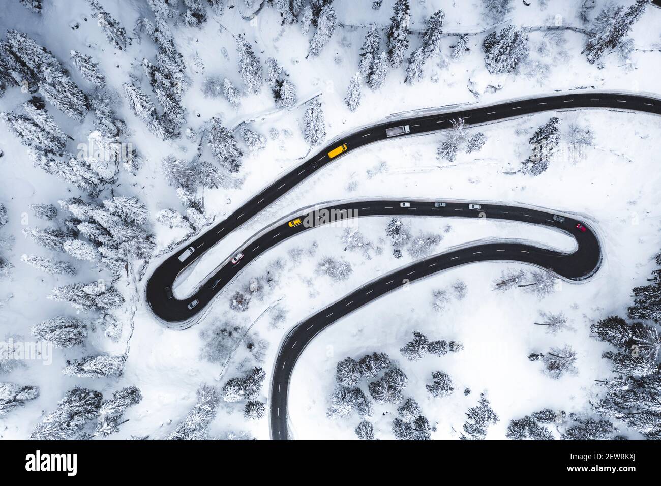 Aerial view of cars driving on narrow bends of mountain road in the snow, Switzerland, Europe Stock Photo