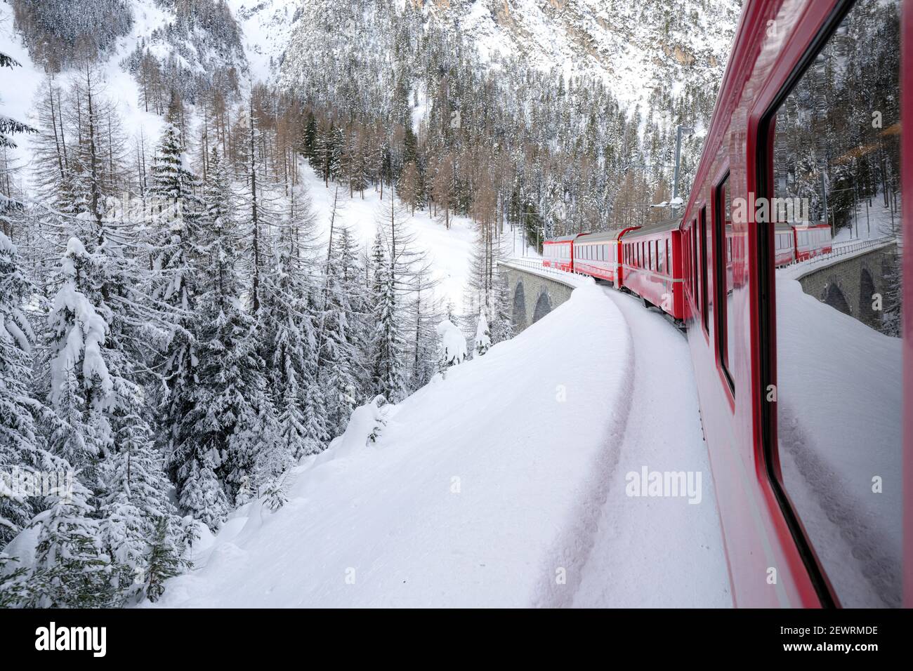 Bernina Express train in the alpine landscape covered with snow, Preda Bergun, Albula Valley, Graubunden Canton, Switzerland, Europe Stock Photo