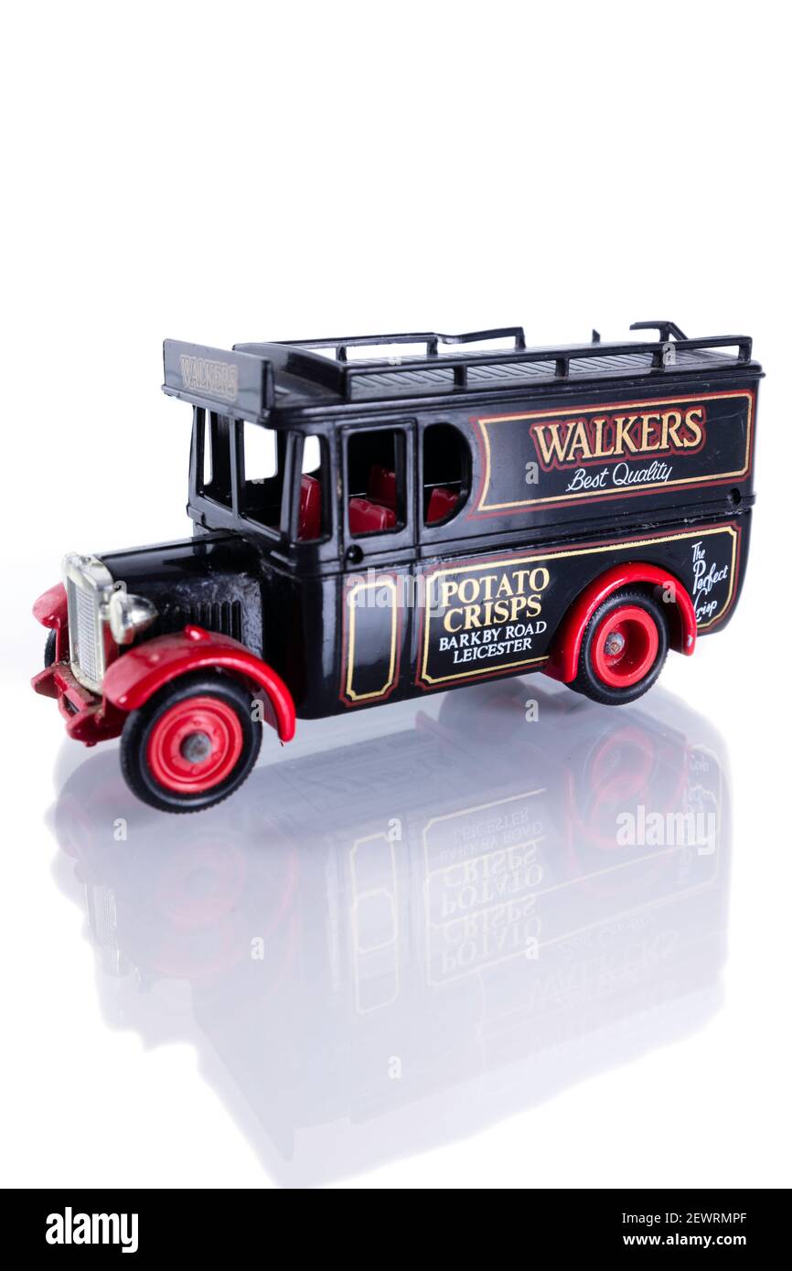 Worn diecast model of a Walkers crisps van. Isolated on a white background, with reflection