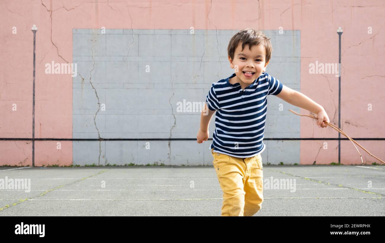 Little boy running towards camera on basque pelota court Stock Photo