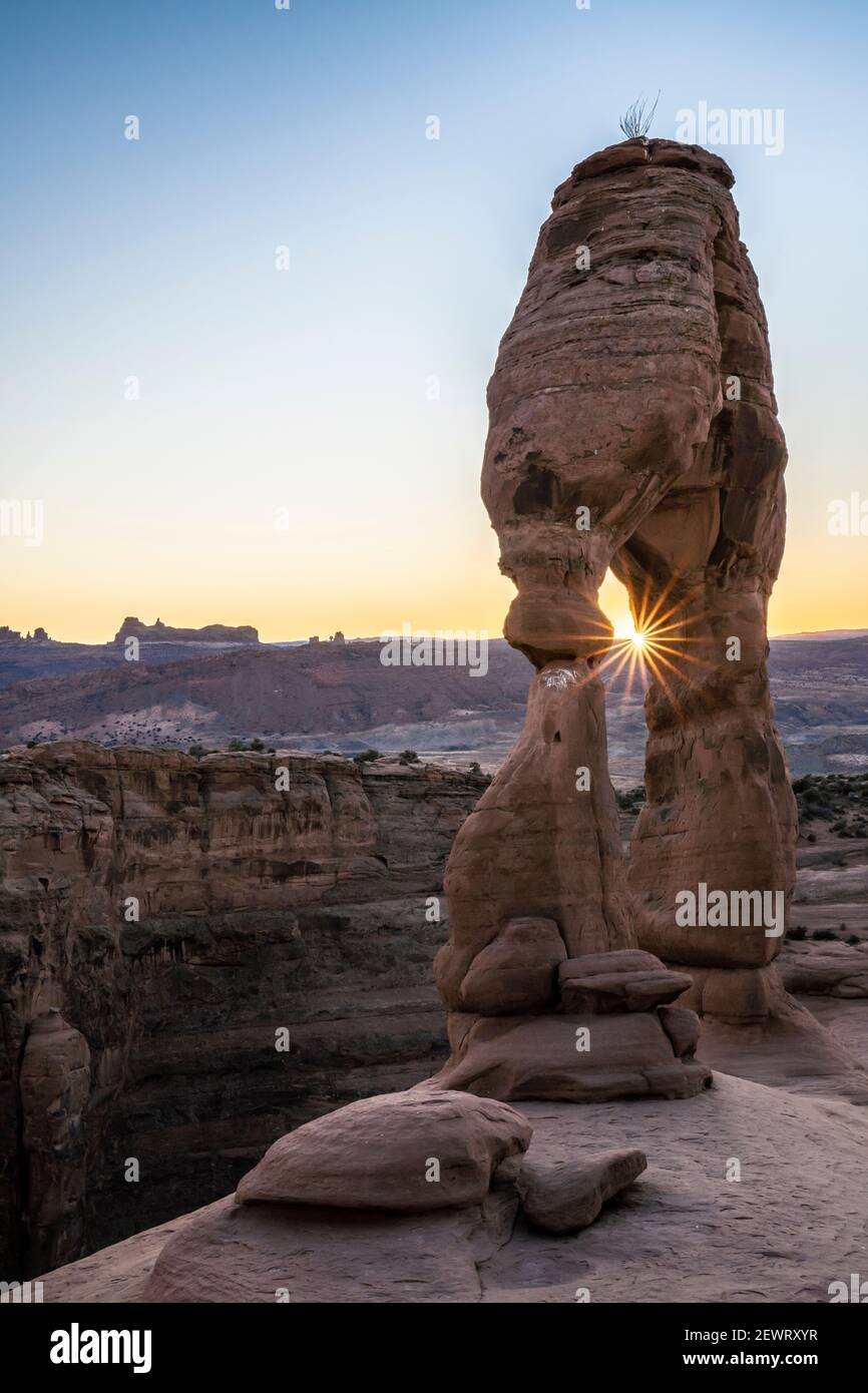 Delicate Arch at sunset with sunburst, Arches National Park, Utah, United States of America, North America Stock Photo