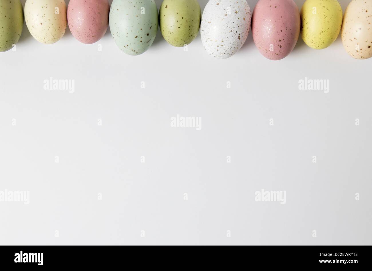 Speckled pastel easter eggs in a horizontal line on white background Stock Photo
