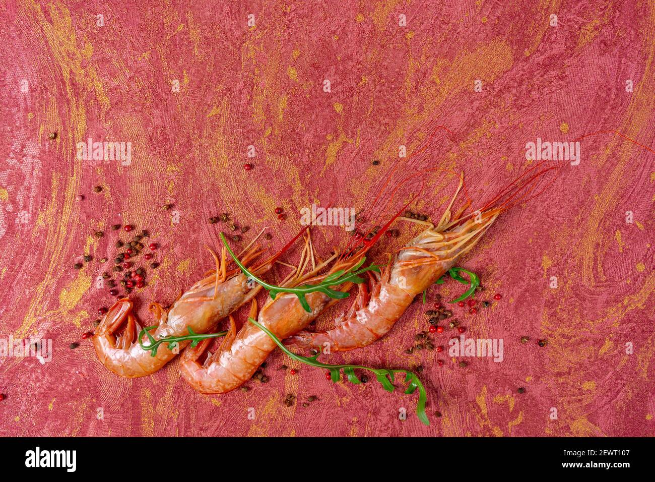 Juicy fresh shrimp seamless pattern isolated on red background. Place for your text. Shrimp seamless pattern on a red background. Seafood shrimp backg Stock Photo