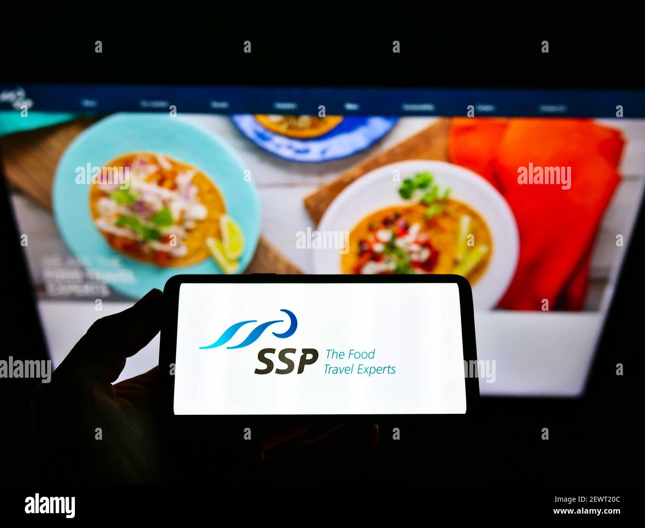 Person Holding Cellphone With Business Logo Of British Food Service Company Ssp Group Plc On Screen In Front Of Website Focus On Phone Display Stock Photo Alamy