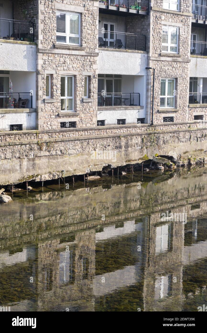 High levels of flood water eroding the structure of riverside apartments Stock Photo