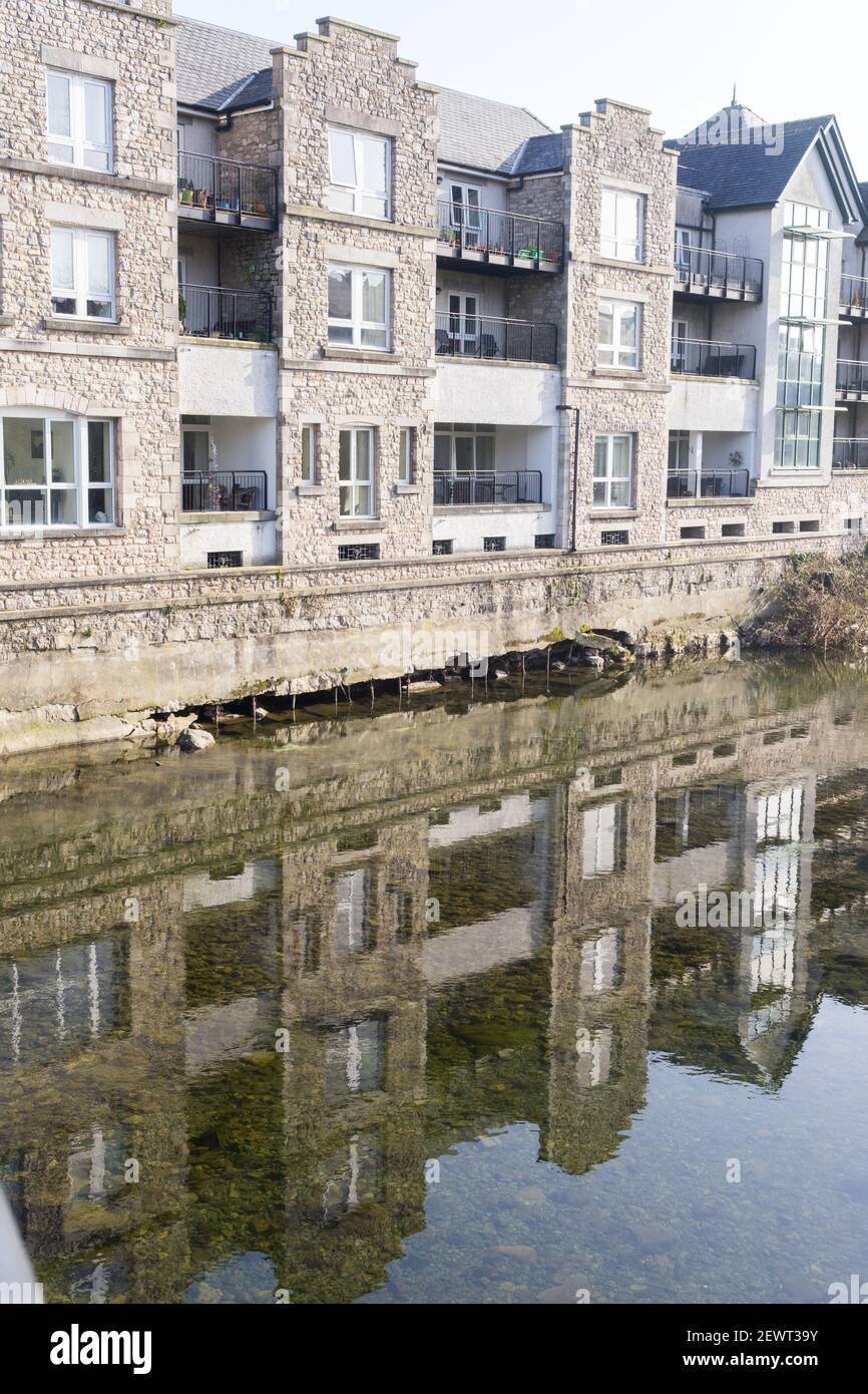 High levels of flood water eroding the structure of riverside apartments Stock Photo