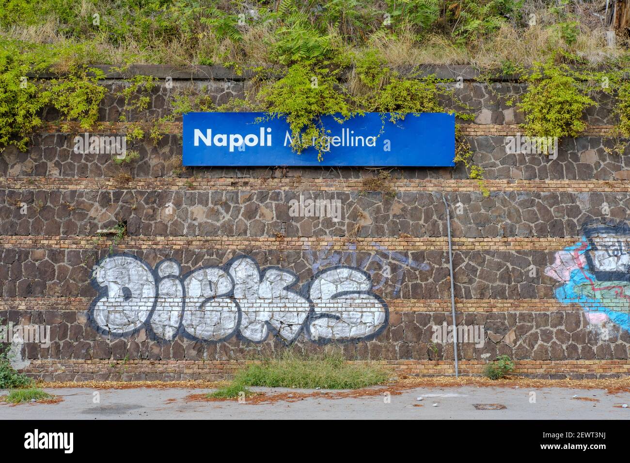 Overgrown station sign at Napoli Mergellina in Naples, Italy, in October 2019. Stock Photo