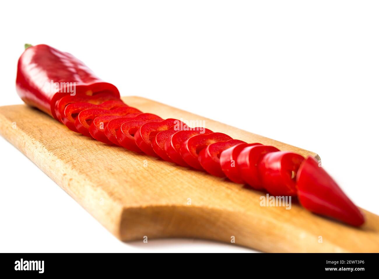Red pepper chopped on a kitchen board closeup, isolated on a white