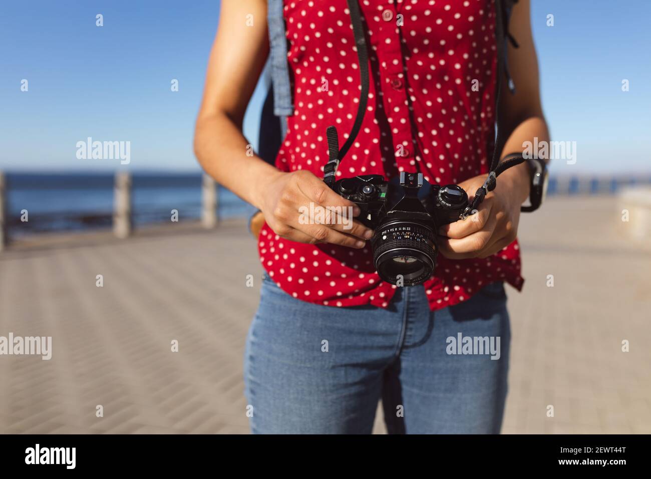 Midsection of african american woman taking photos on promenade by the sea Stock Photo