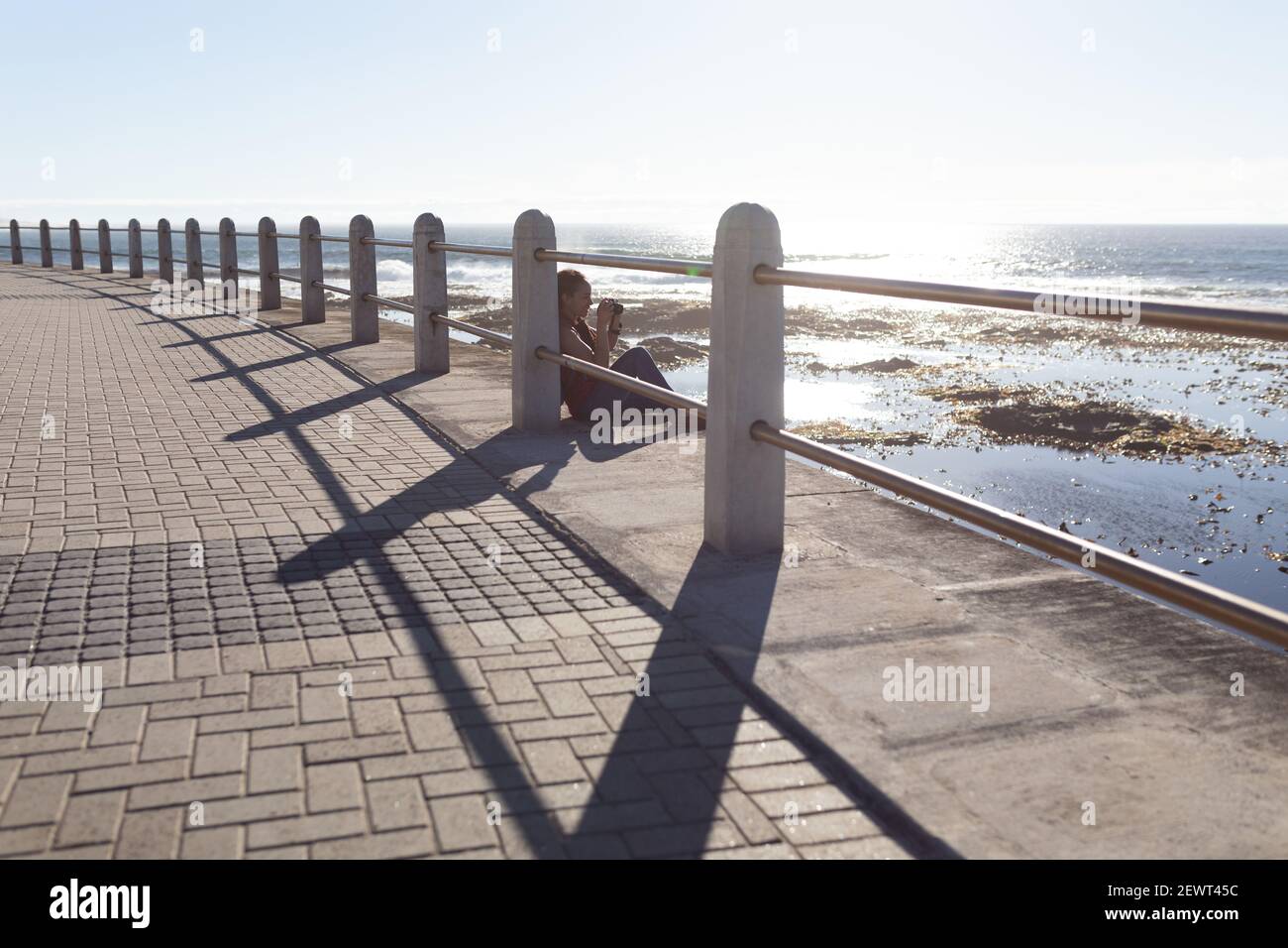 Happy african american woman taking photos on promenade by the sea Stock Photo