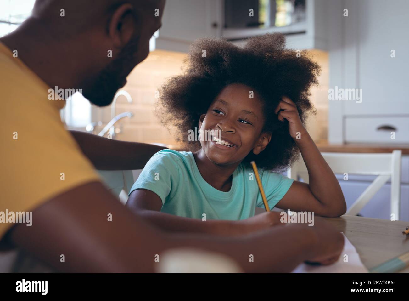 African american girl doing homework with her father Stock Photo