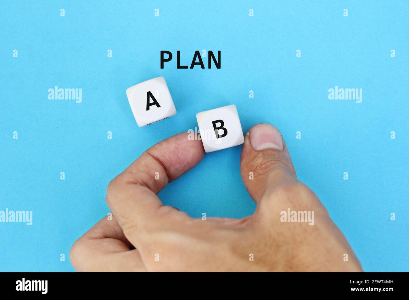 Hand of a businessman choosing business plan b out of two options on Blue background. Business strategy and decisions concept. Stock Photo