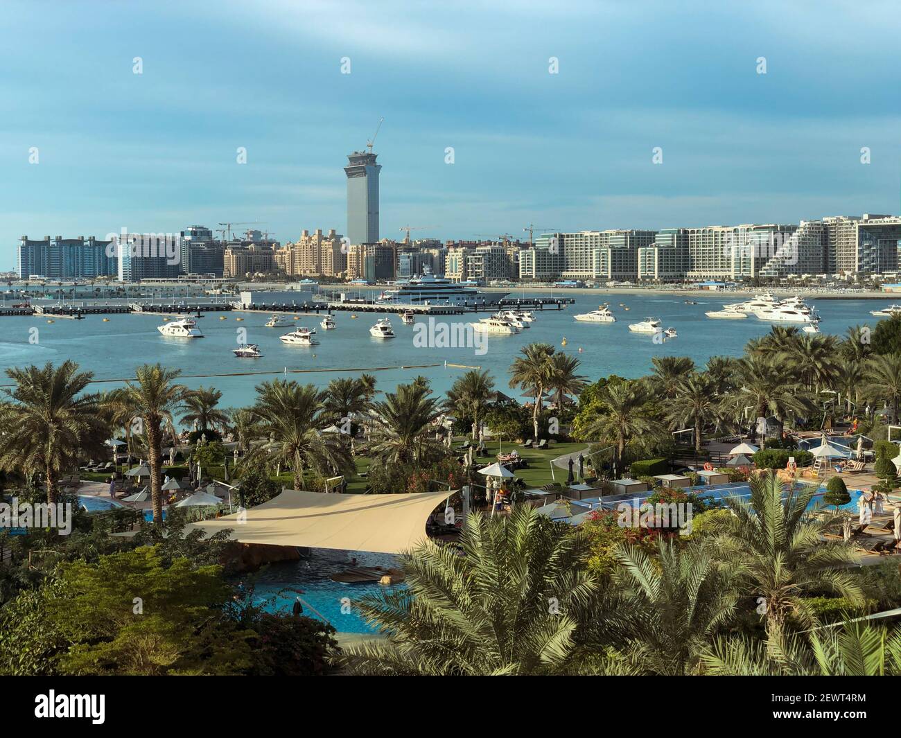 Daytime view of the poolside garden, the marina and the beautiful buildings on the palm island in Dubai, UAE. Stock Photo