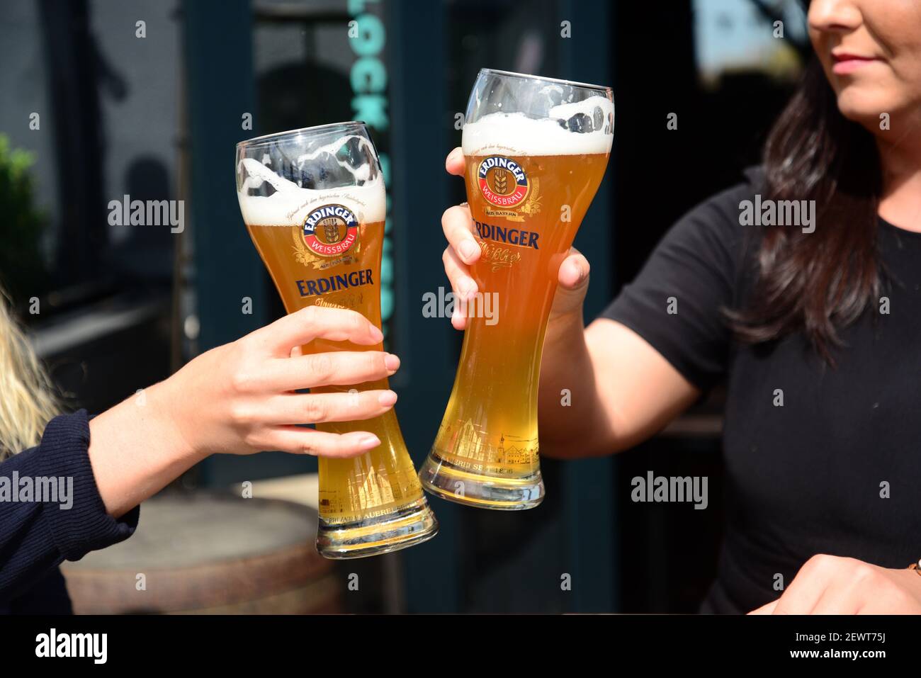 Two women clicking pints of Erdinger beer in a pub in Camden, London Stock Photo