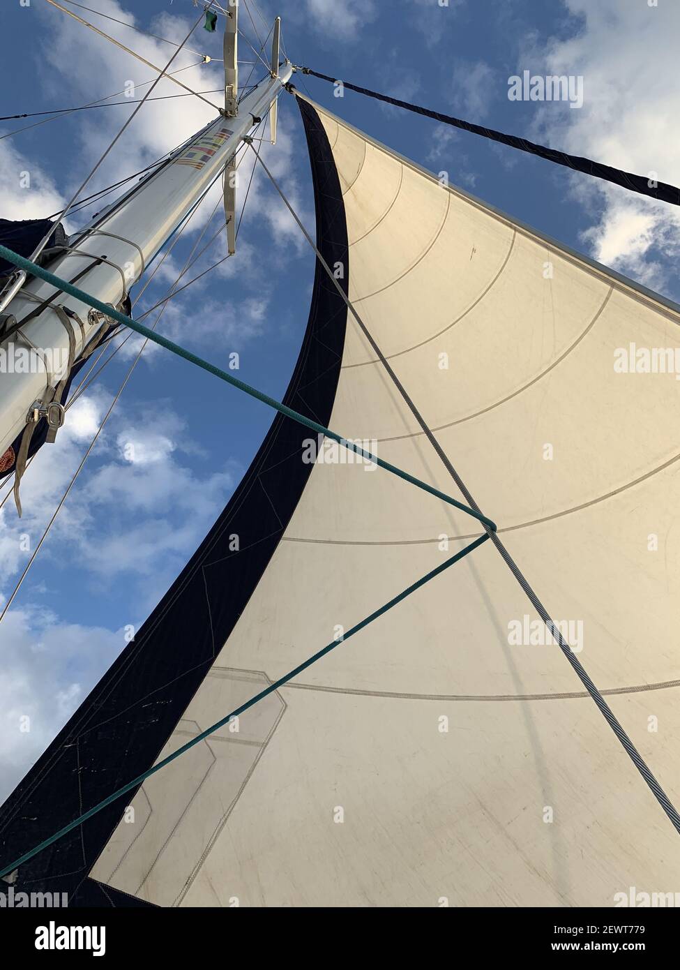 A vertical shot of a large full sail on a sailing yacht off the coast ...