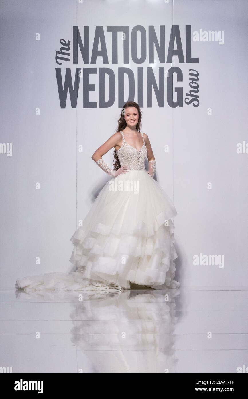 Female black model in long dress on runway at National Wedding Show, London Stock Photo