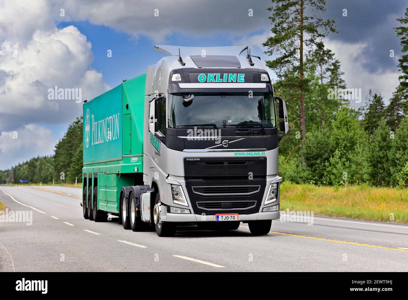 Silver Volvo FH truck of Okline Oy pulls Pilkington glass trailer along Highway 25 on a day of summer. Raasepori, Finland. July 24, 2020. Stock Photo