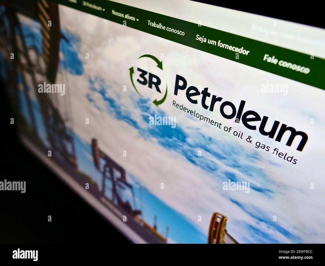 High angle view of business website with logo of Brazilian oil and gas company 3R Petroleum S.A. on screen. Focus on right of monitor. Stock Photo