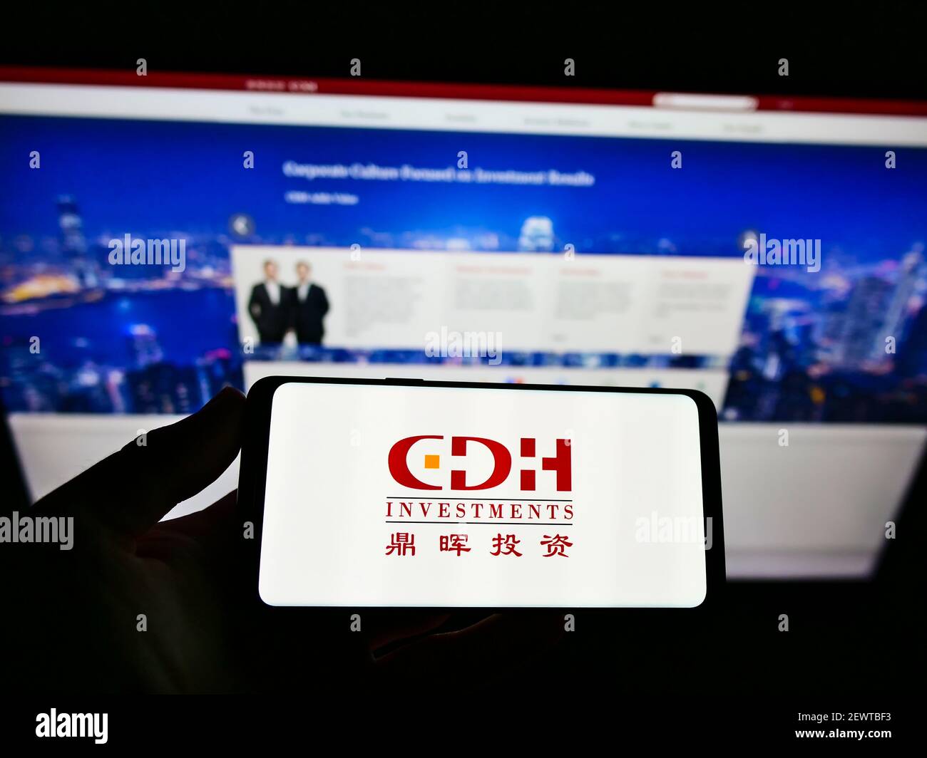 Person holding cellphone with logo of Chinese alternative investment  company CDH Investments on screen in front of webpage. Focus on phone  display Stock Photo - Alamy