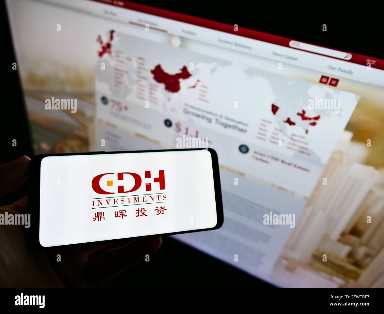 Person holding mobile phone with business logo of Chinese investment  company CDH Investments on screen in front of web page. Focus on phone  display Stock Photo - Alamy