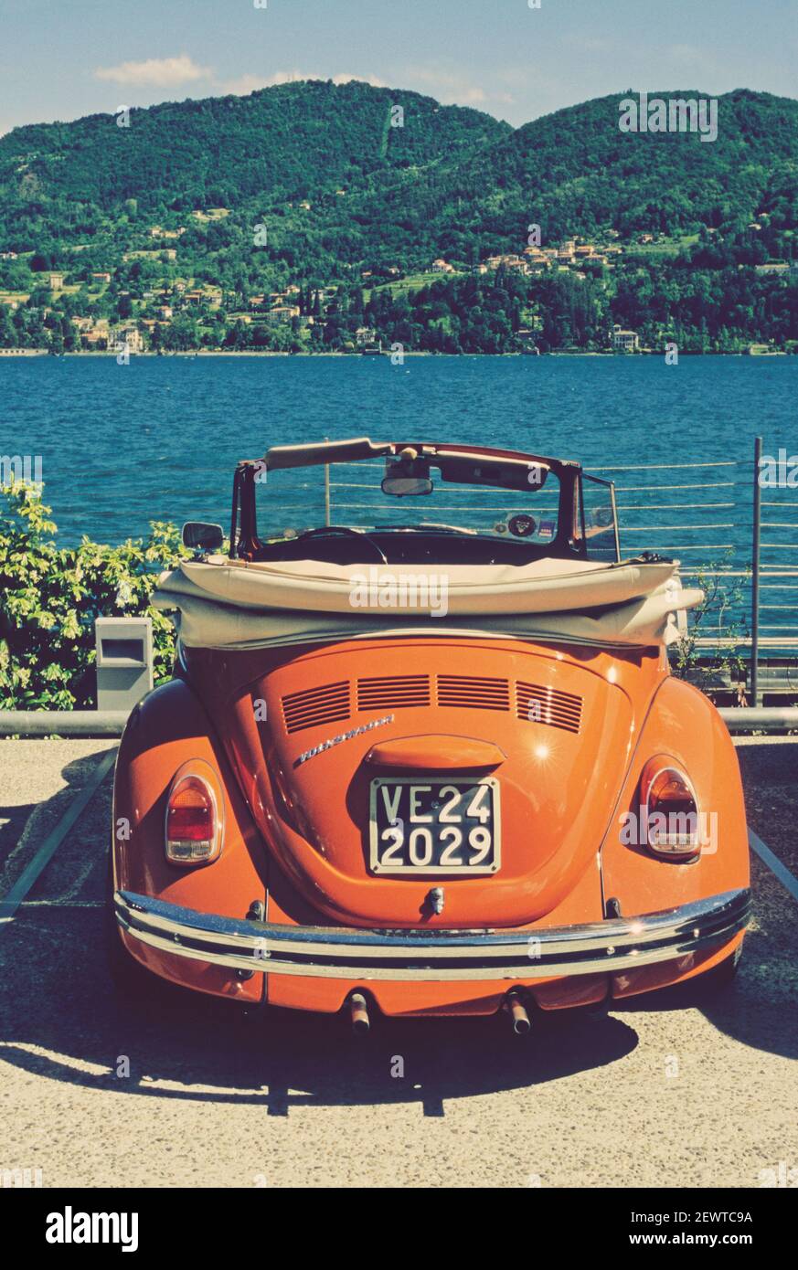 orange convertible vw beetle in front of the Lake Como, Italy Stock Photo