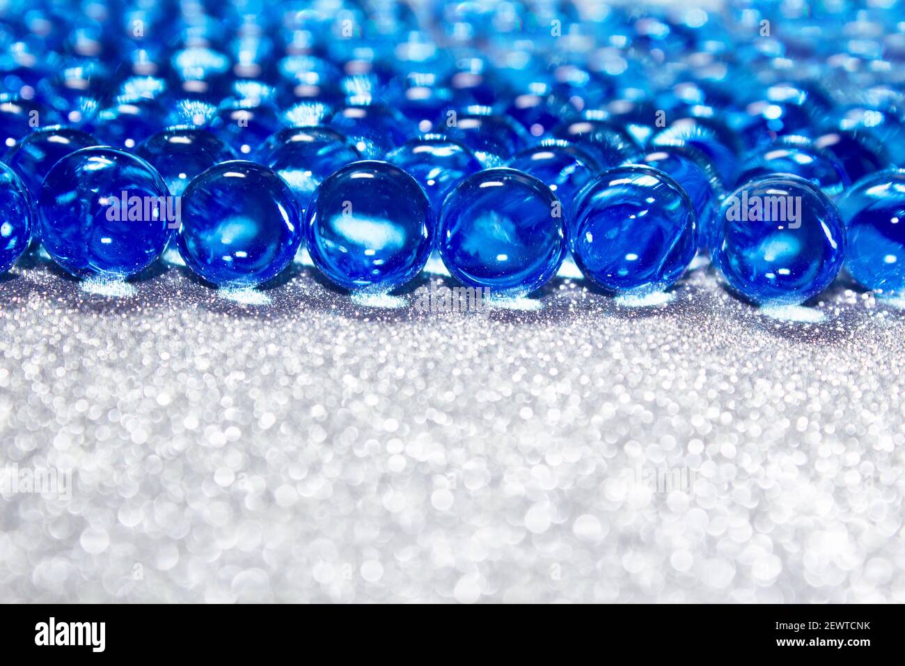 Water blue gel balls on silver shiny background. Polymer gel. Silica