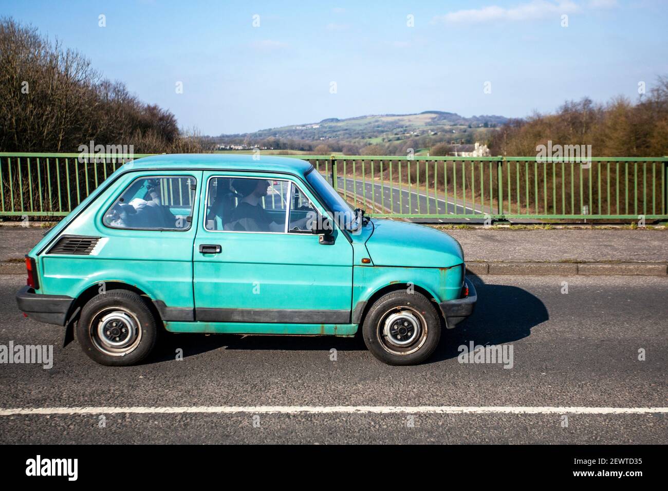 1993, 90s, 2dr blue Fiat Type 126, a four passenger, rear-engined city car that was introduced by Fiat in October 1972; Classic cars, cherished veteran, restored old timer, collectible motors, vintage heritage, old preserved, collectable cars crossing the M6 motorway highway road network, UK Stock Photo