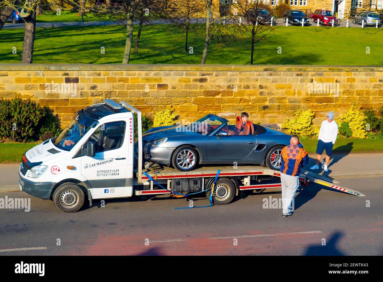 A recovery vehicle rescuing a Porsche sports car on a Sunday afternoon in North Yorkshire here the car has been pulled on to the recovery vehicle Stock Photo