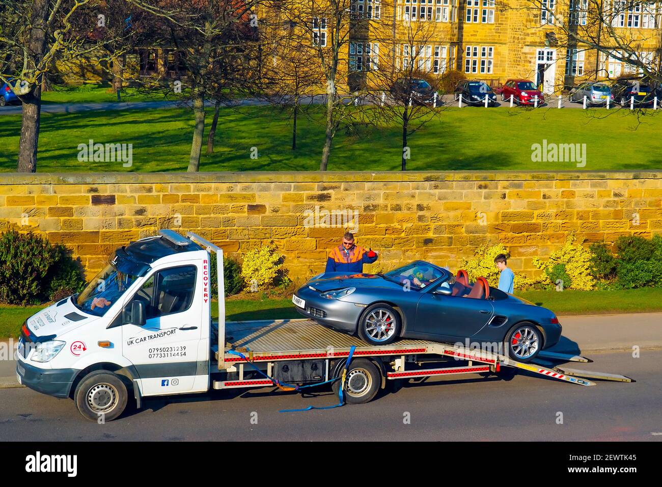 A recovery vehicle rescuing a Porsche sports car on a Sunday afternoon in North Yorkshire here the car is being winched on to the recovery vehicle Stock Photo