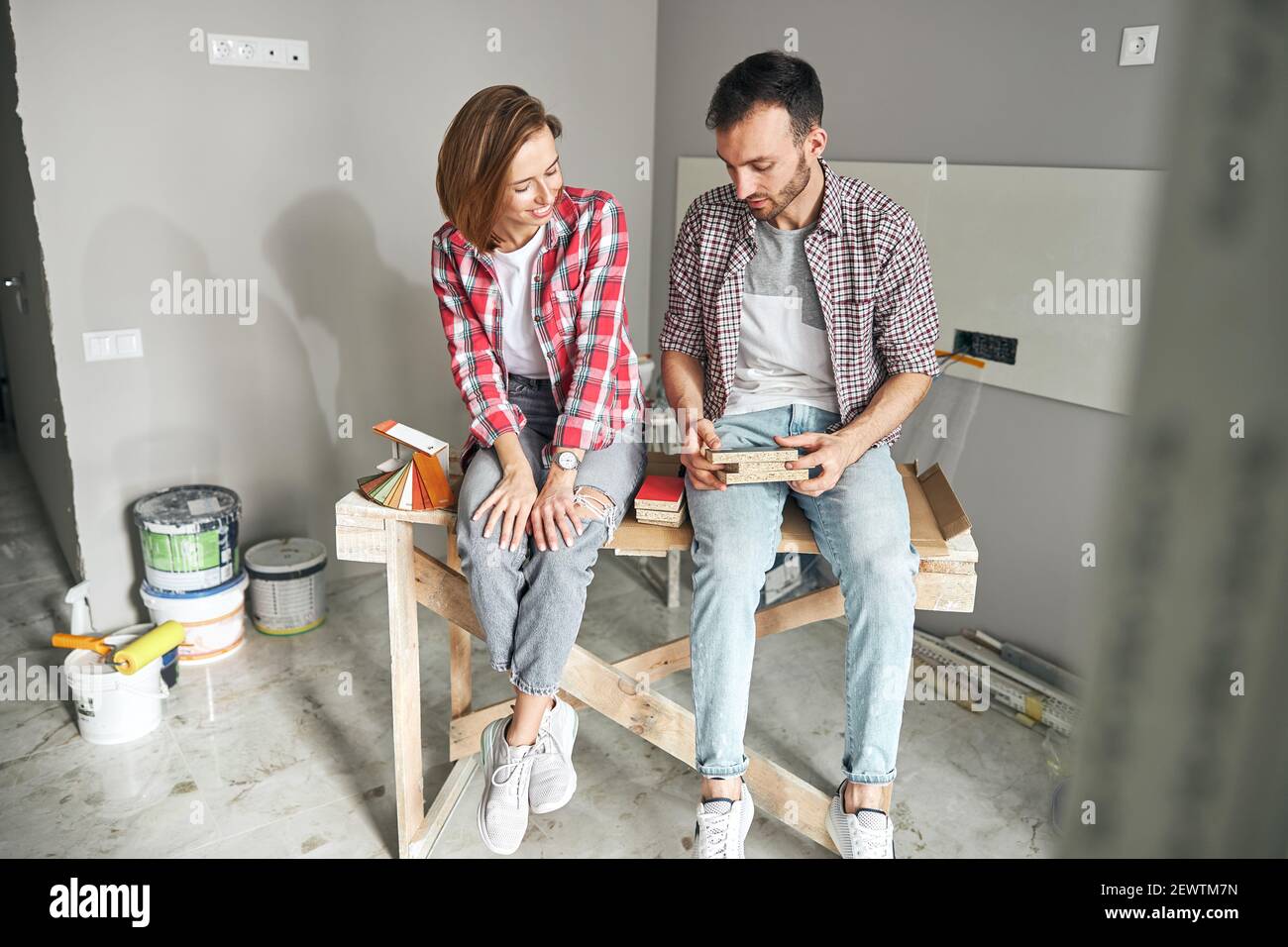 Two skilled young workers discussing flooring materials Stock Photo