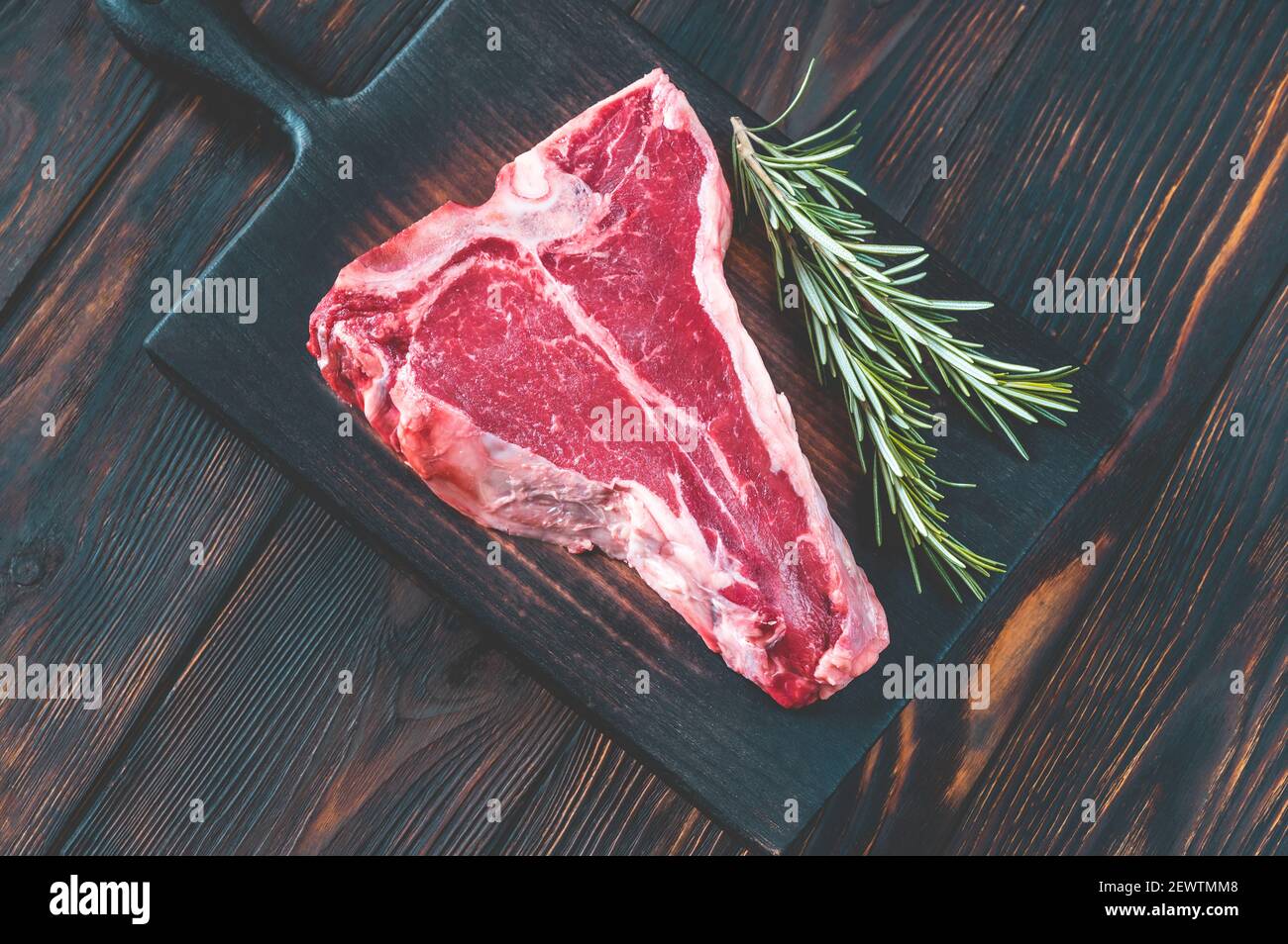 Raw Tbone steak with fresh rosemary and red peppercorn Stock Photo Alamy