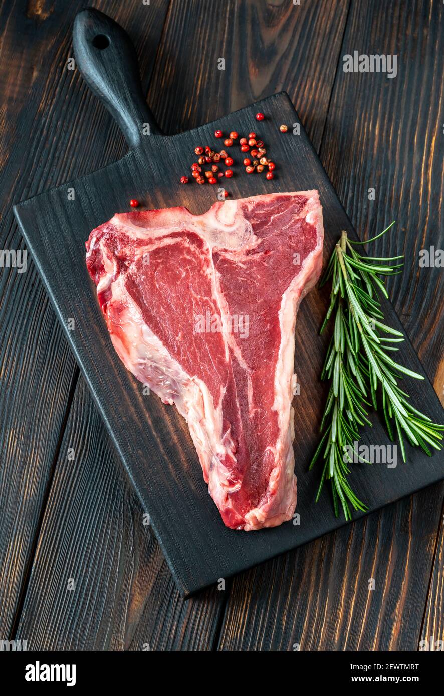 Raw Tbone steak with fresh rosemary and red peppercorn Stock Photo Alamy