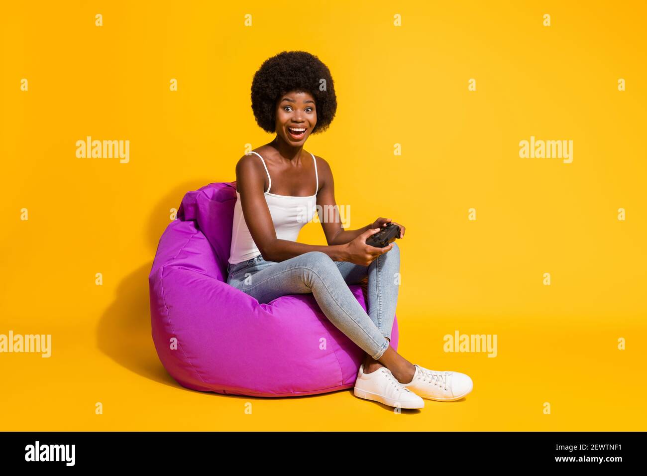 Photo of surprised funny young woman wear casual clothes sitting bean bag  playstation hands arms isolated yellow color background Stock Photo - Alamy