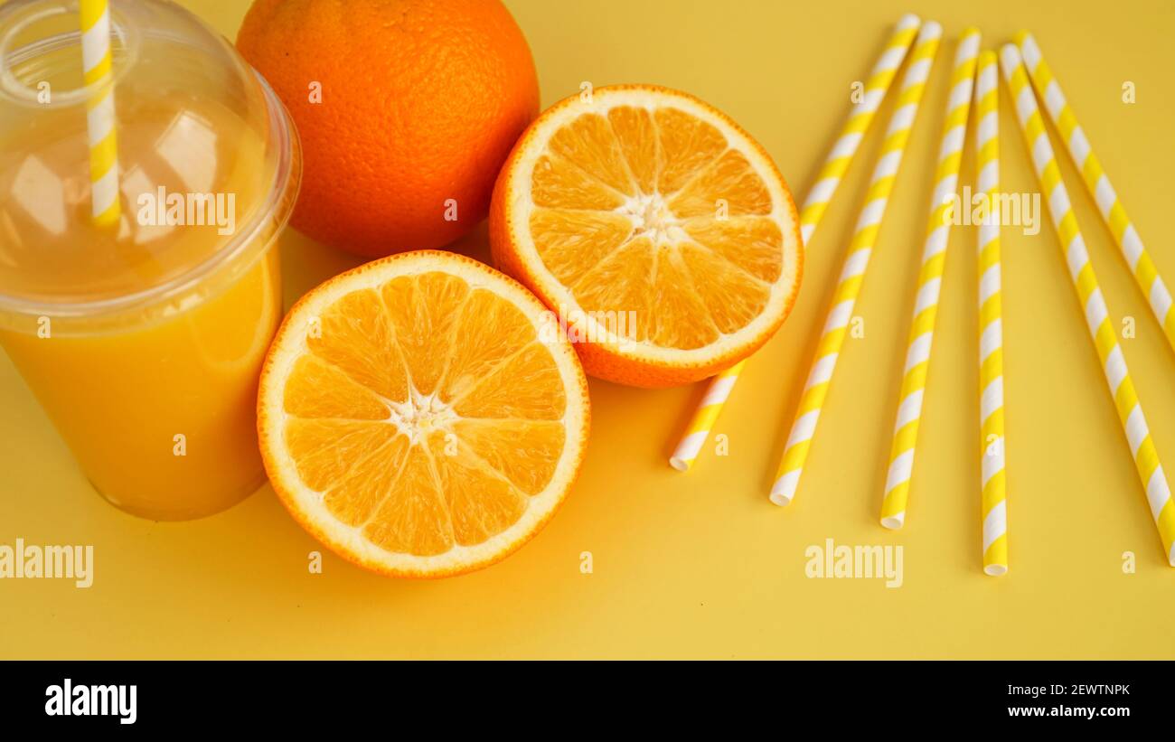 Orange juice in fast food closed cup with tube on yellow background Stock Photo Alamy