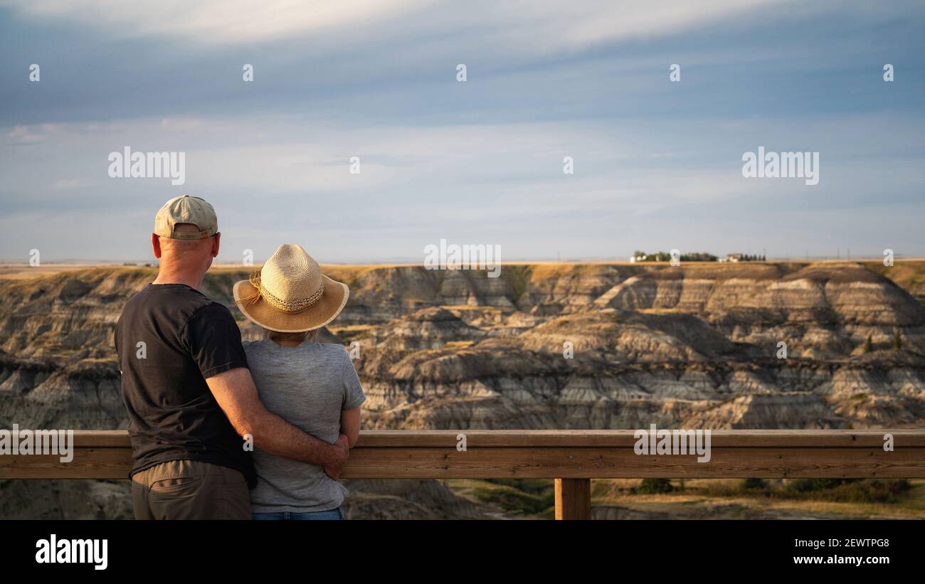 Active senior couple looking at view at Horseshoe Canyon near Drumheller in Alberta, Canada. Stock Photo