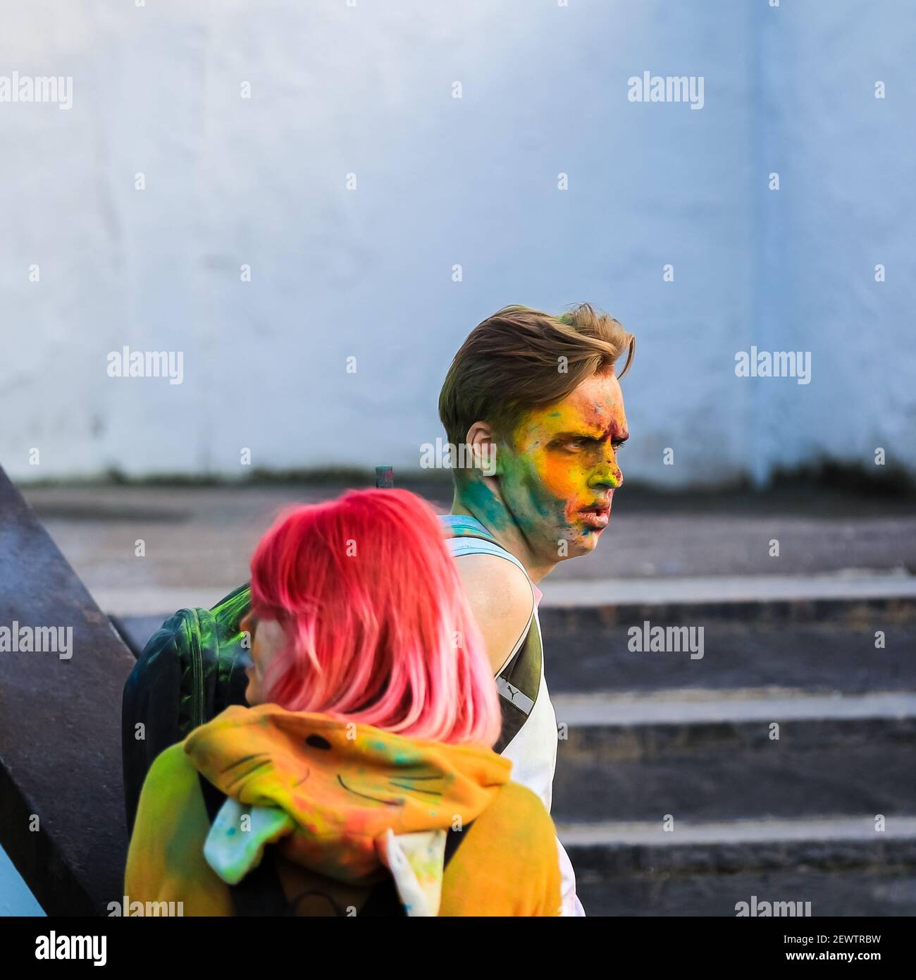 Russia, Moscow - June 25, 2017. Portrait of a young man with bright colors on his face. Laughs with happiness. Holi is a traditional holiday in India Stock Photo