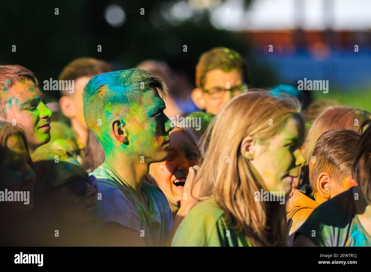 Russia, Moscow - June 25, 2017. Portrait of a young man with bright colors on his face. Laughs with happiness. Holi is a traditional holiday in India Stock Photo