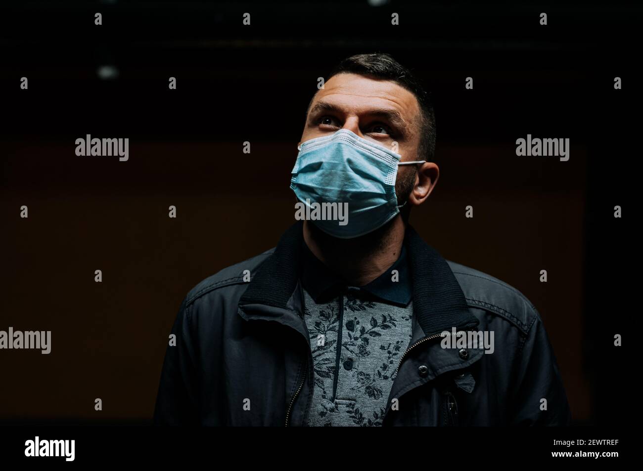 Portrait of man wearing a mask on dark black background Stock Photo - Alamy