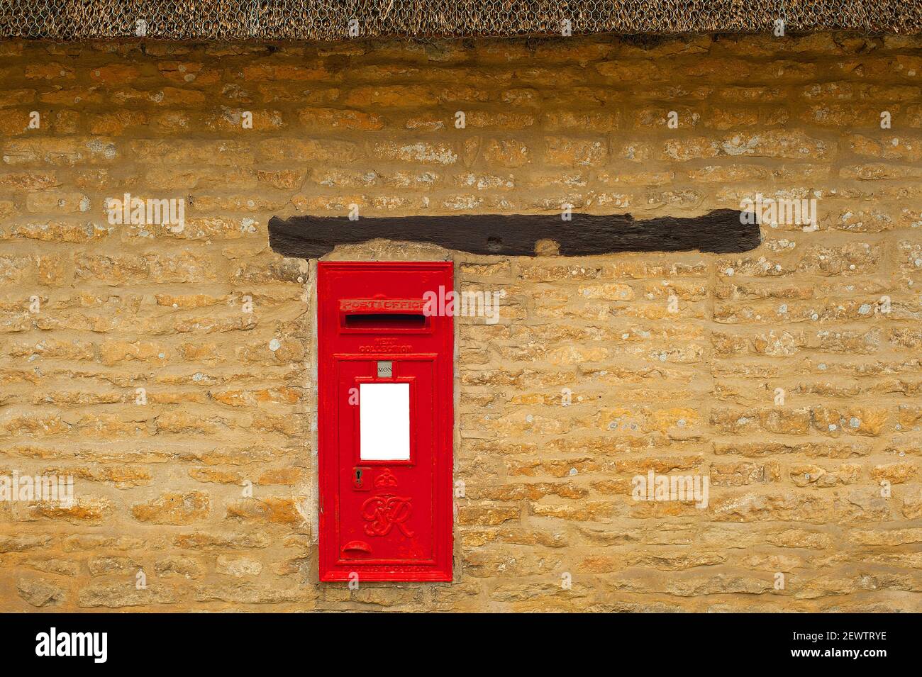 Red Post box built Into Sandstone Wall Stock Photo