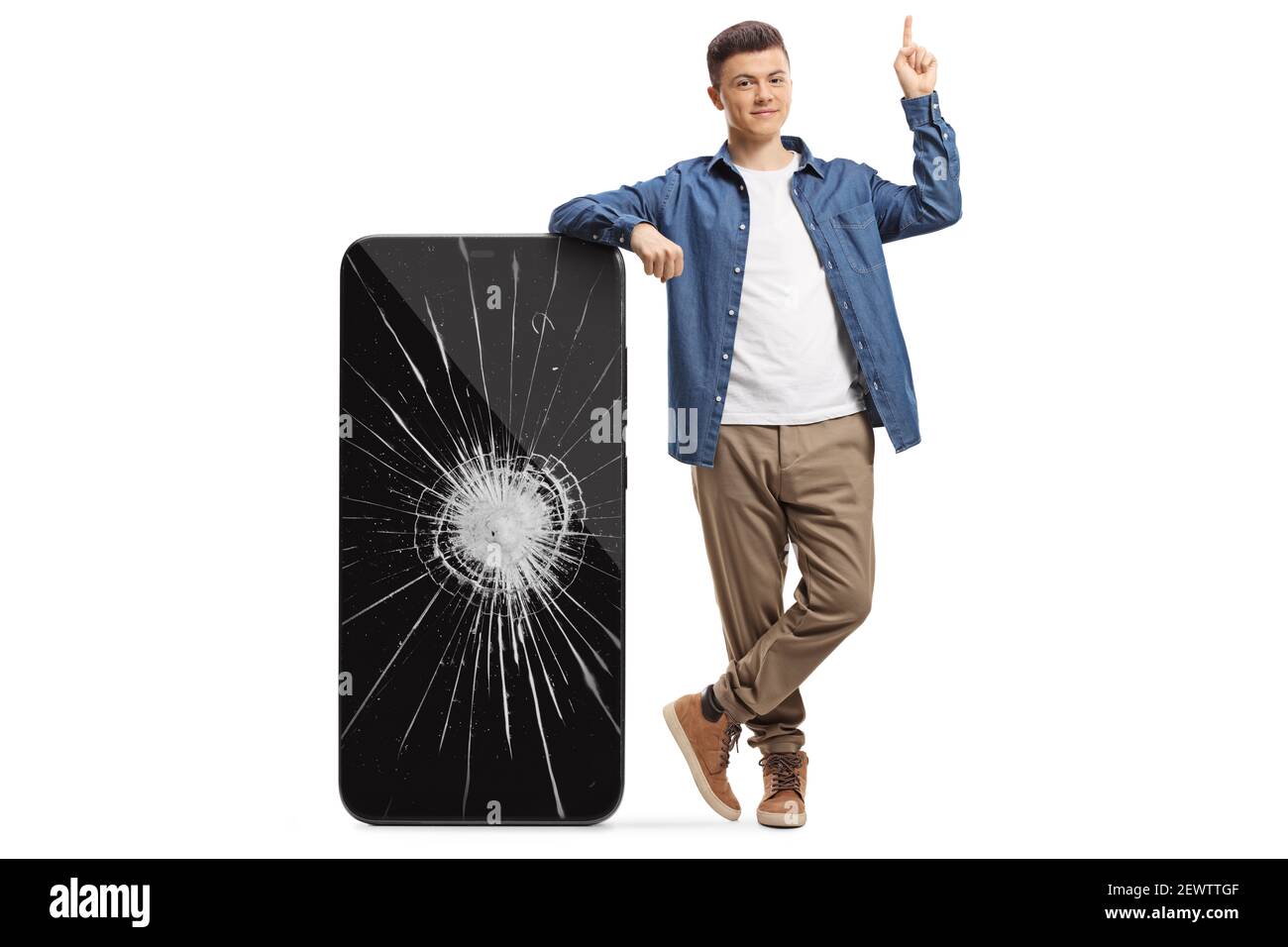 Full length portrait of a guy pointing up and posing with a big smartphone with cracked screen isolated on white background Stock Photo