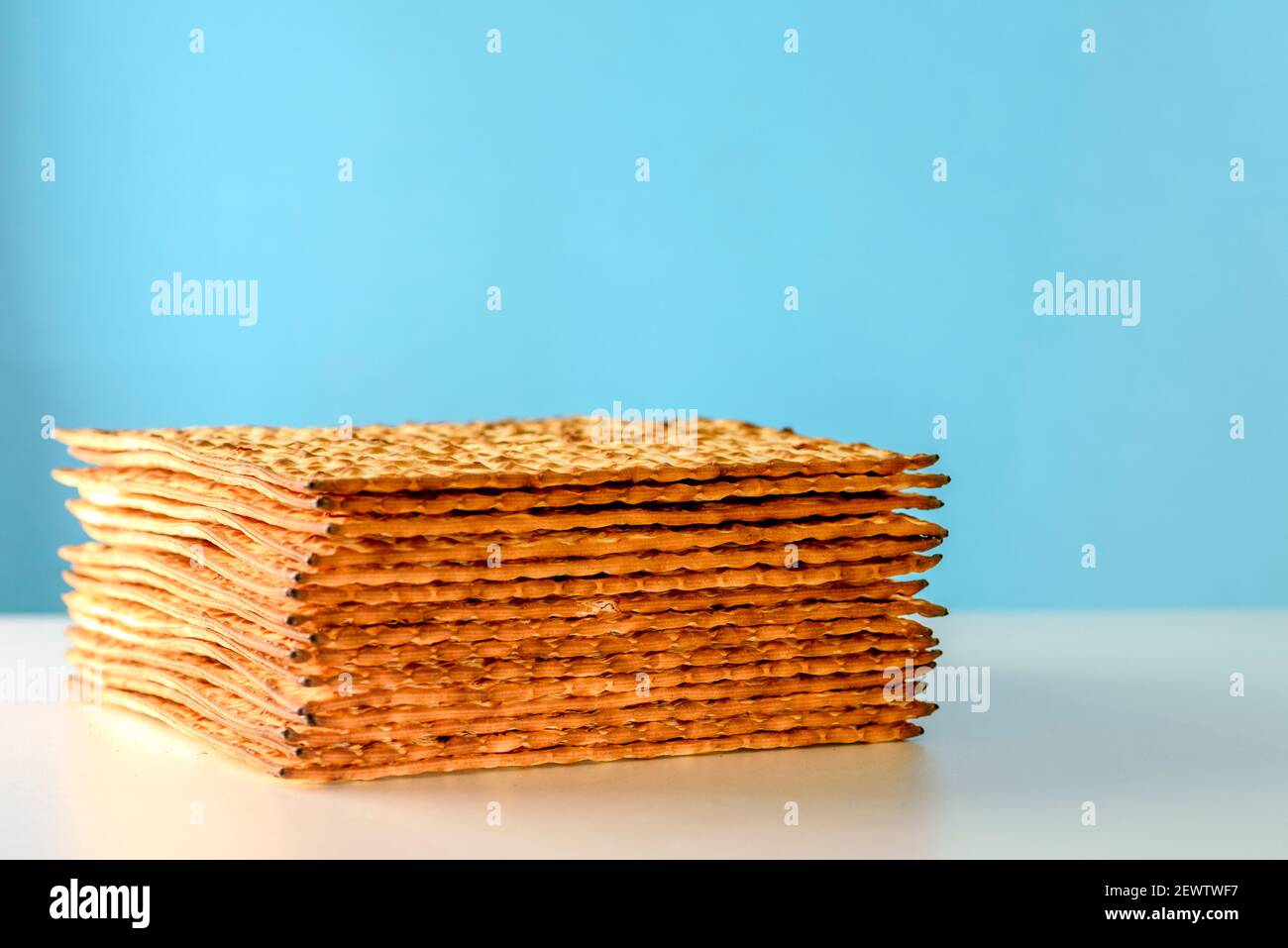 Matzah on white table over blue background.Matza Jewish traditional