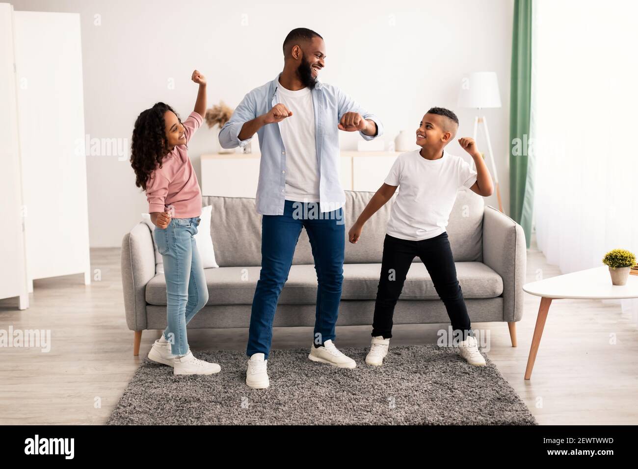 African american dad dancing to music with his little children Stock Photo