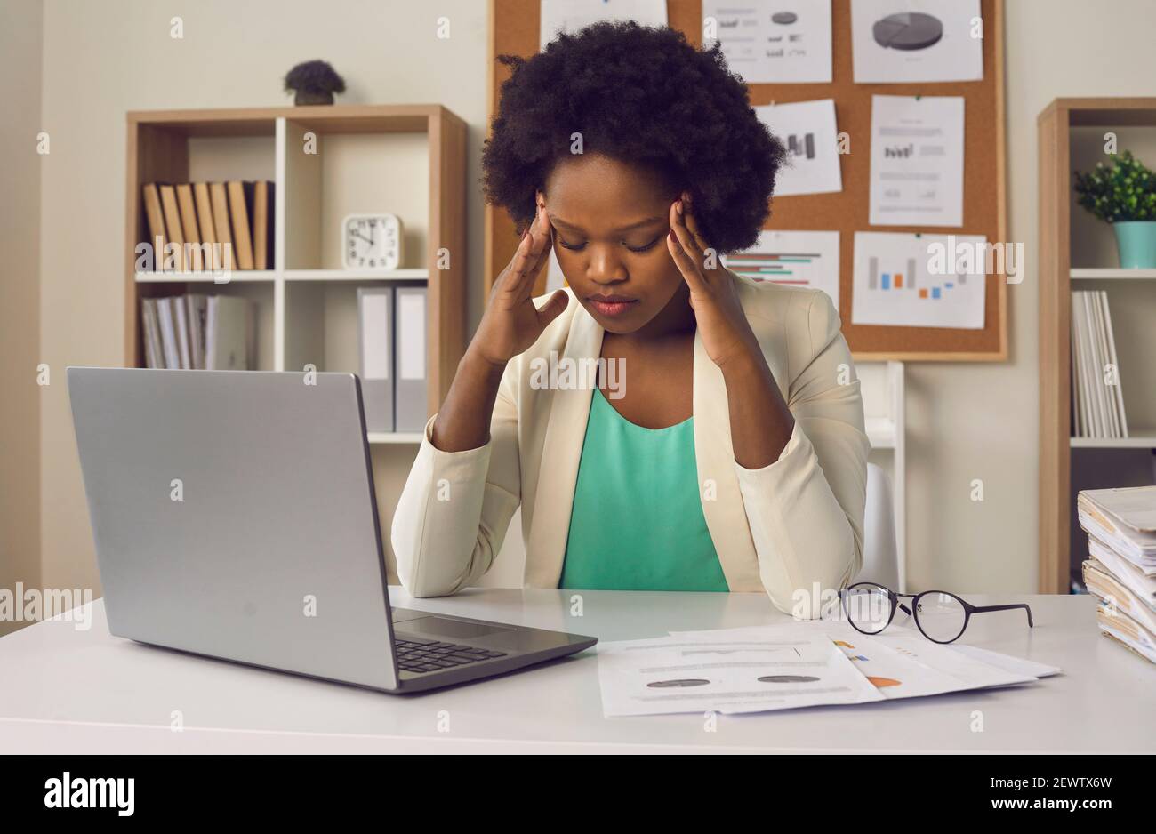 Overworked african american millennial woman feeling strong headache sit front of laptop Stock Photo