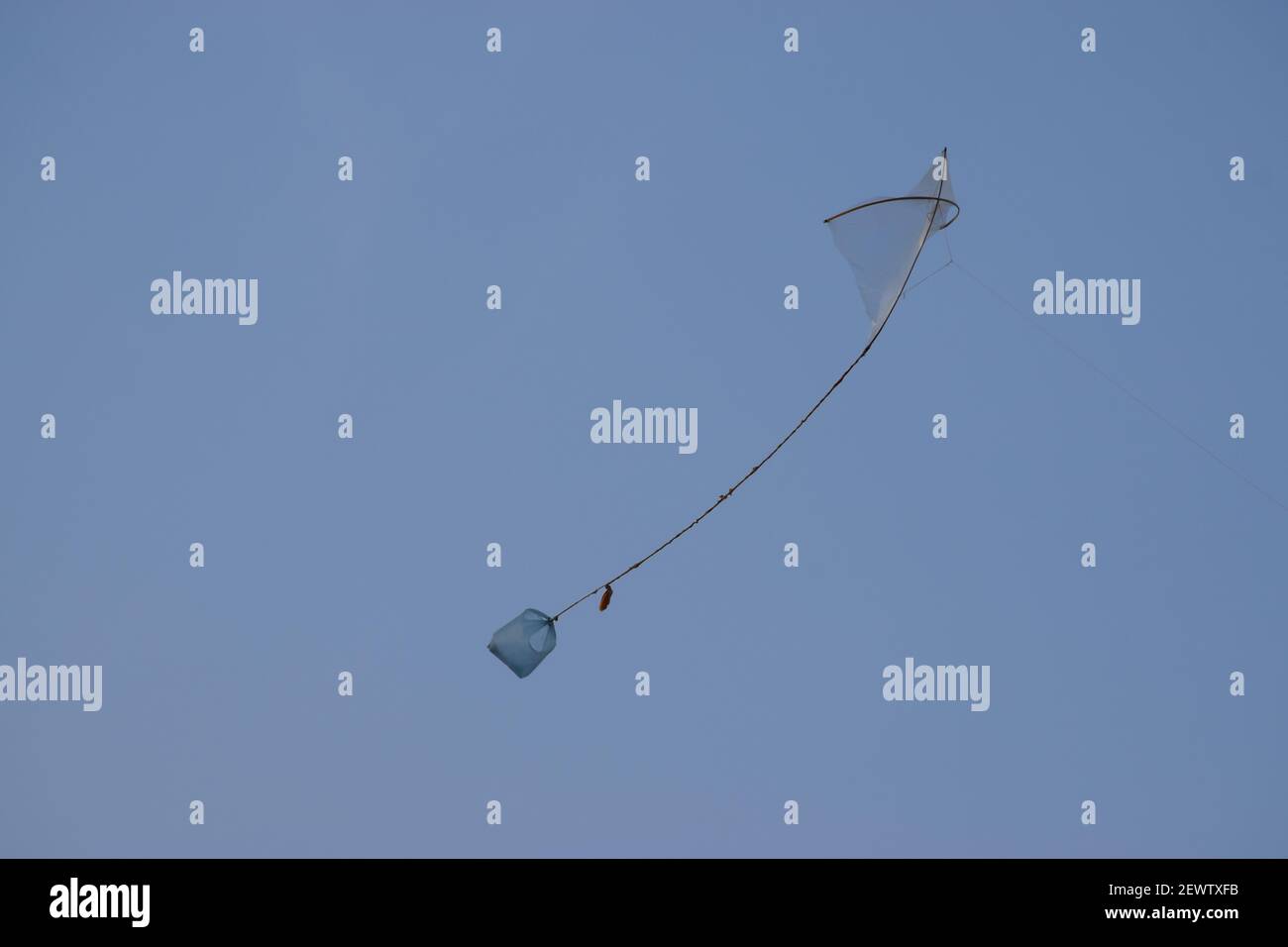 kite flying against a blue sky. Asian childhood game air tail Pakistan