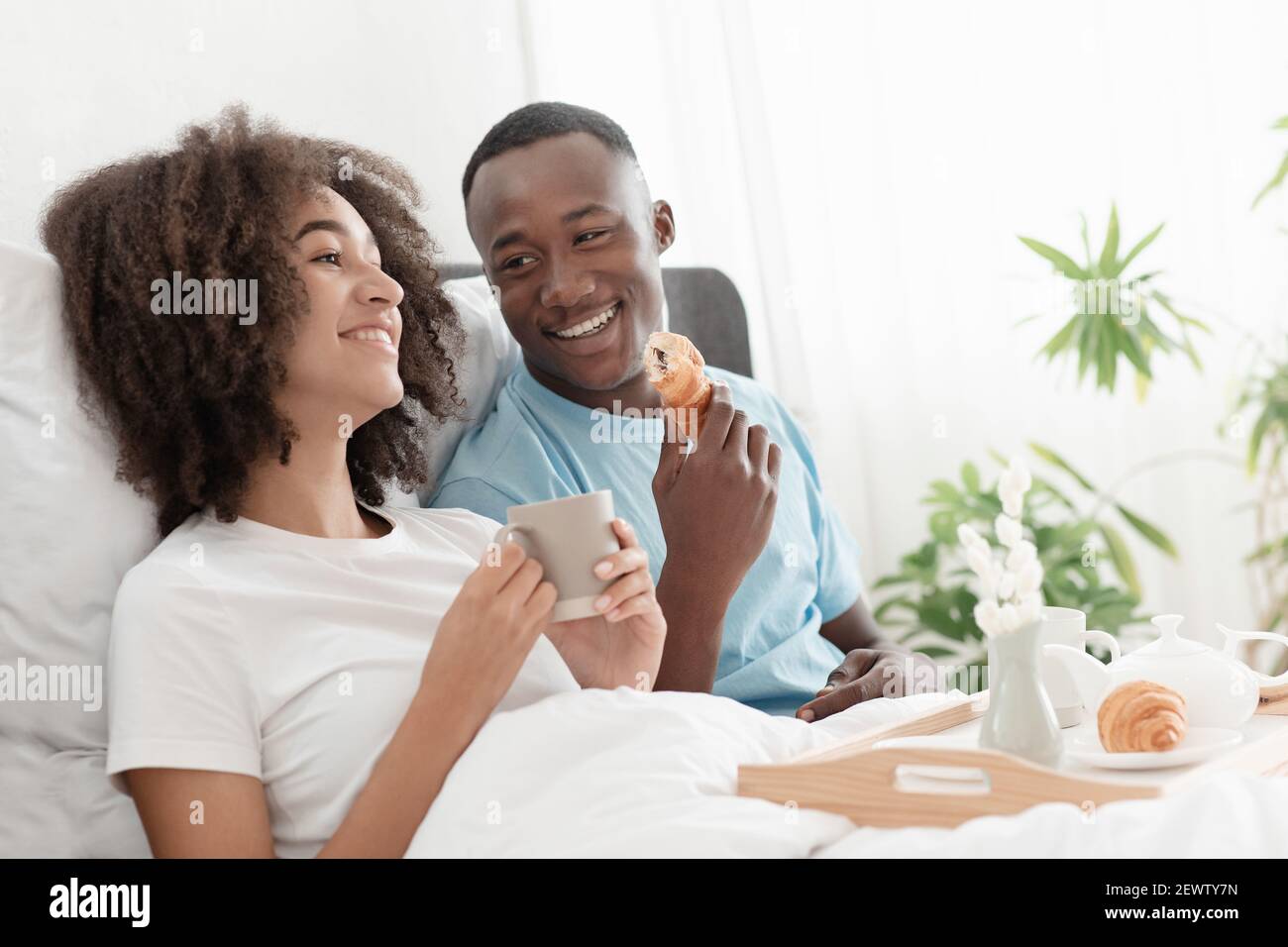 Breakfast in bed together at morning and good mood during covid-19 quarantine Stock Photo